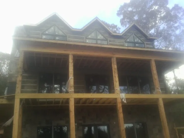 Dormers and porch framing on a large log home under construction — Roof Coating work by our crew in Racine
